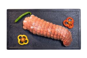 Raw Tied Beef Roast on Black Tray With Peppers and Chili